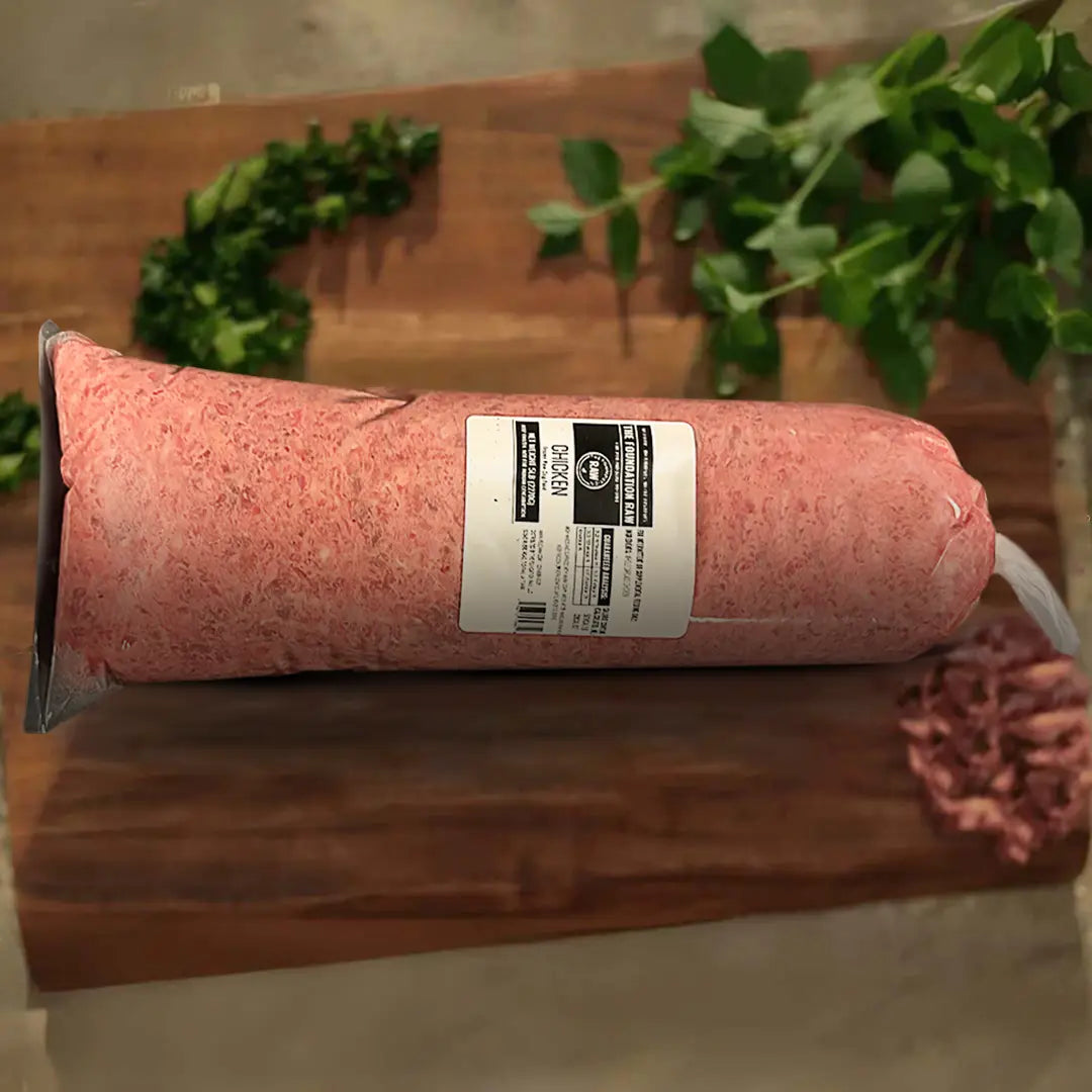 chicken frozen raw dog food packed meat at the top of a wooden board