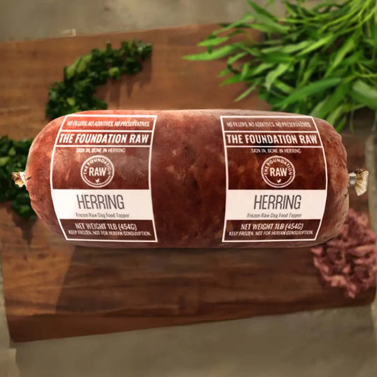 Rolled herring with 'The Foundation Raw' labels on a wooden surface.  ground herring dog food roll ground herring raw food diet for dogs raw dog food raw dog food roll fish for dog fish meat