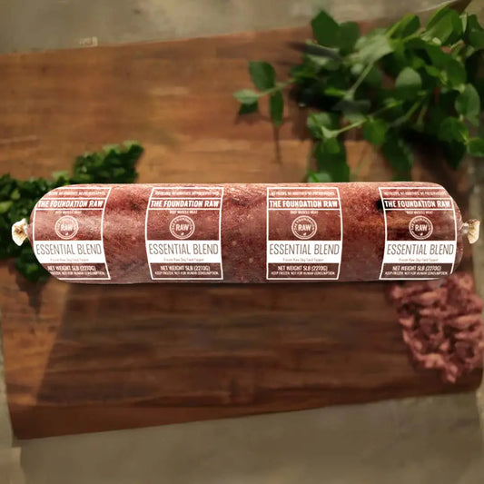 Rolled raw meat product with 'The Foundation Raw' labels on a wooden surface. essential blend raw beef dog food beef muscle meat beef fat beef muscles raw food diet for dogs raw dog food raw dog food roll