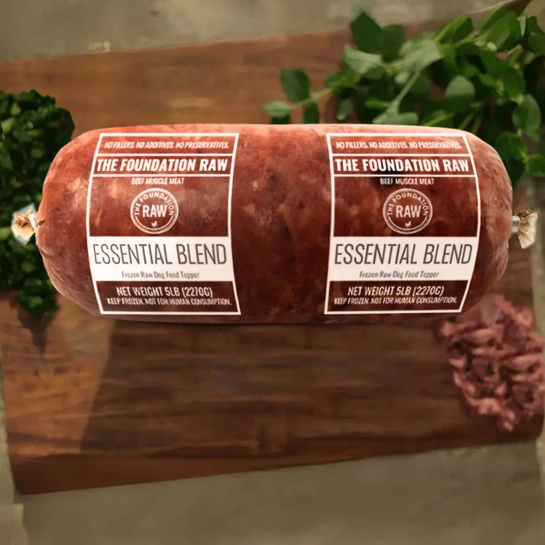 Rolled raw meat product with 'The Foundation Raw' labels on a wooden surface. essential blend raw beef dog food beef muscle meat beef fat beef muscles raw food diet for dogs raw dog food raw dog food roll
