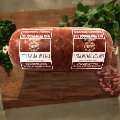 Rolled raw meat product with 'The Foundation Raw' labels on a wooden surface. essential blend raw beef dog food beef muscle meat beef fat beef muscles raw food diet for dogs raw dog food raw dog food roll