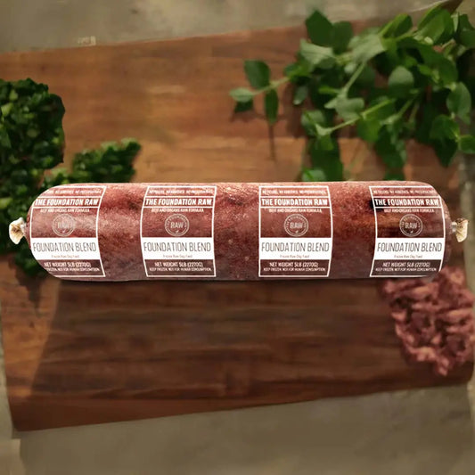 Rolled raw meat product on a wooden surface. foundation blend raw beef dog food beef muscle meat green tripe beef liver beef kidney beef spleen raw food diet for dogs raw dog food raw dog food roll