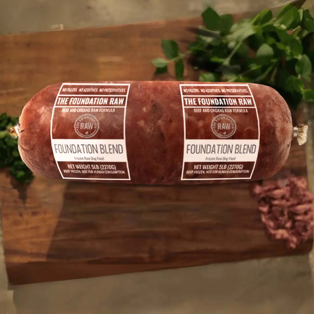 Rolled raw meat product on a wooden surface. foundation blend raw beef dog food beef muscle meat green tripe beef liver beef kidney beef spleen raw food diet for dogs raw dog food raw dog food roll
