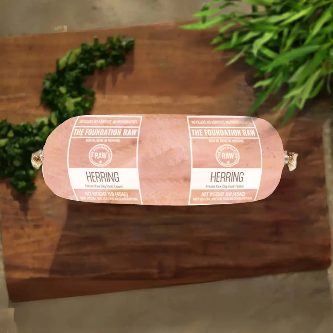 Rolled herring on a wooden board with greenery in the background