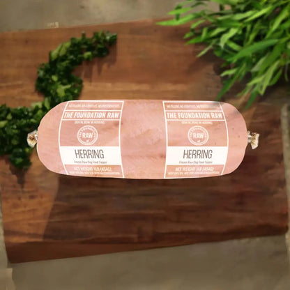 Rolled herring on a wooden board with greenery in the background