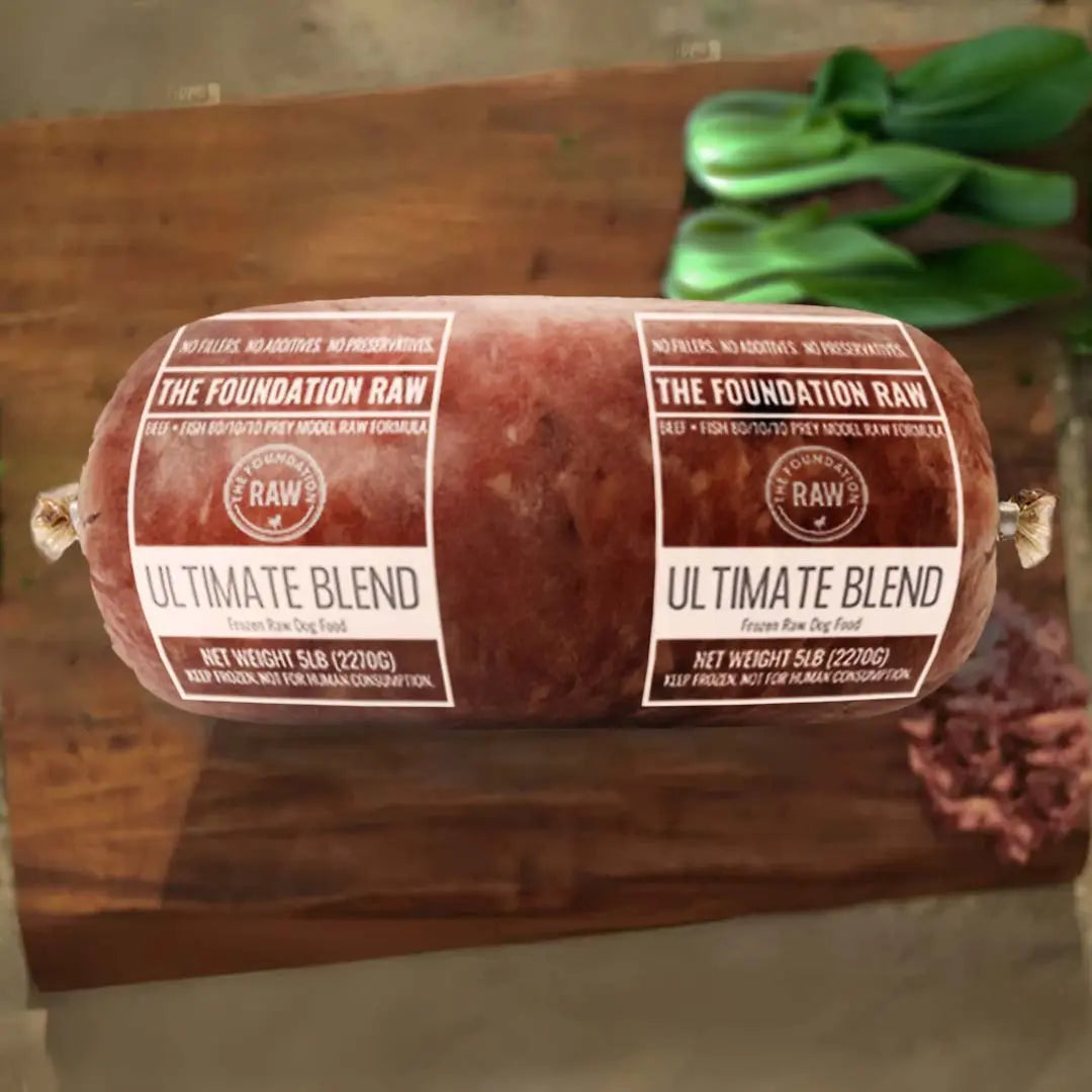 Rolled meat product with 'The Foundation Raw' labels on a wooden surface ultimate blend raw beef dog food  ground bone beef muscle meat green tripe beef liver beef kidney beef spleen pollock raw food diet for dogs raw dog food raw dog food roll dog food chub