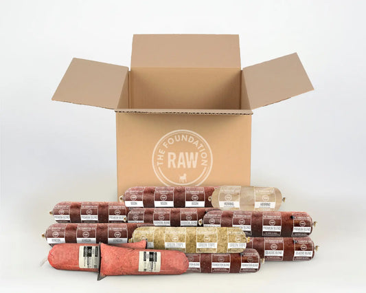 Open cardboard box with 'The Butcher's Box' logo and various sausages on a white background